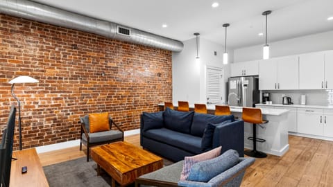 Relax in the modern living area, featuring exposed brick and a sleeper sofa for additional guests.
