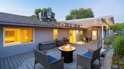 Covered deck with a fire pit and outdoor dining