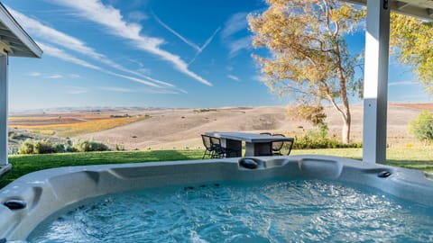 Soak beneath the covered patio with open hill views