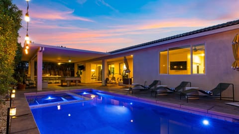 Private pool and lounge area under twilight skies.