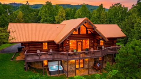 Log cabin exterior surrounded by lush trees.