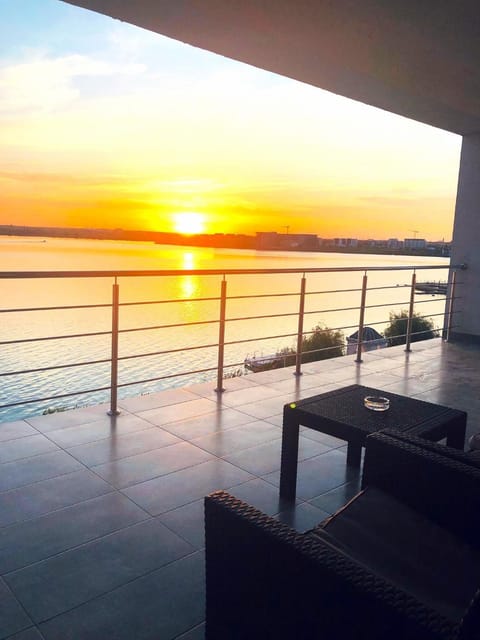 Property building, View (from property/room), Balcony/Terrace, Seating area, Dining area, Lake view, Sunset