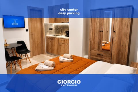 Bed, TV and multimedia, Kitchen or kitchenette, Photo of the whole room, Bedroom, Text overlay, towels, wardrobe