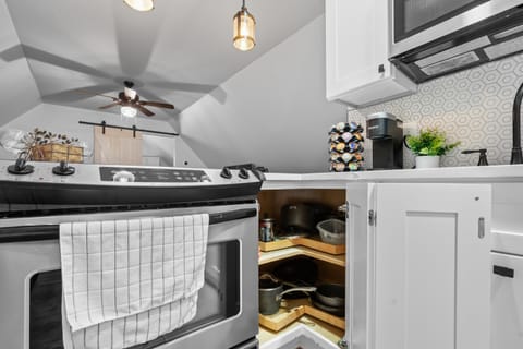 Kitchen or kitchenette, furniture, microwave, oven, stove, towels, air conditioner