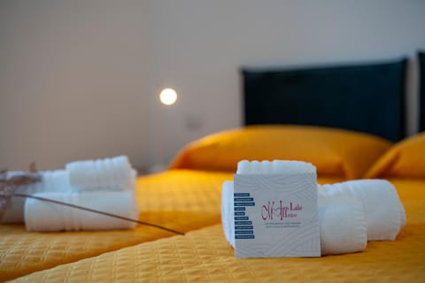 Bed, Photo of the whole room, Bedroom, Text overlay, towels