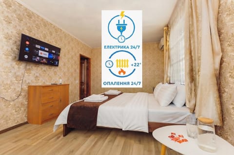 Bed, Property logo or sign, TV and multimedia, Photo of the whole room, Logo/Certificate/Sign, Bedroom, Text overlay, Certificate/Award, towels