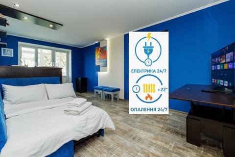 Bed, Property logo or sign, TV and multimedia, Living room, Photo of the whole room, Seating area, Logo/Certificate/Sign, Bedroom, Text overlay, Certificate/Award