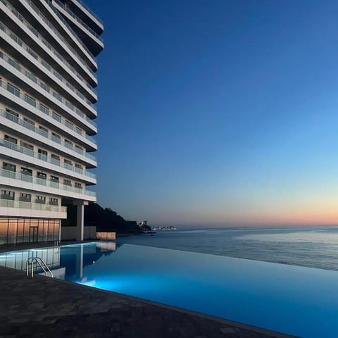 Property building, Natural landscape, Beach, Pool view, Sea view, Swimming pool, Sunset, sunbed