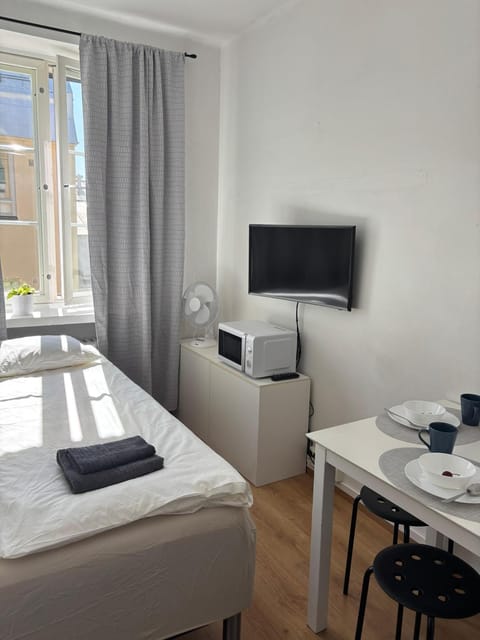 Bed, TV and multimedia, Photo of the whole room, Decorative detail, Decorative detail, Dining area, Bedroom, microwave, towels