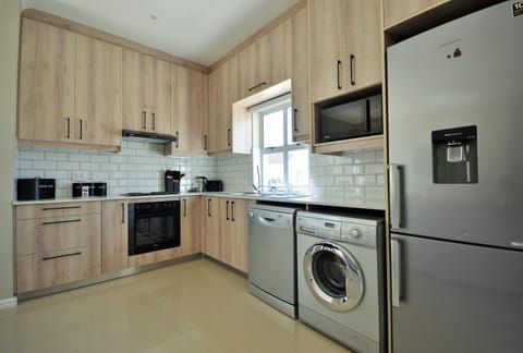 Kitchen or kitchenette, dishwasher, oven, stove, toaster, washing machine, dryer