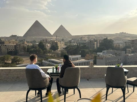 Property building, Patio, Nearby landmark, Restaurant/places to eat, Day, People, View (from property/room), Balcony/Terrace, Living room, Seating area, Guests, City view, Mountain view