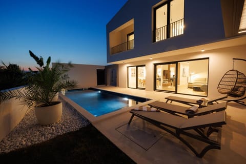 Property building, Patio, Night, Balcony/Terrace, Seating area, Pool view, Swimming pool, Swimming pool, sunbed