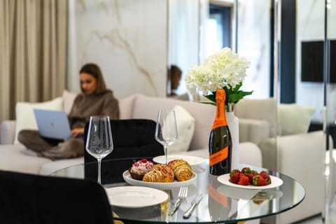 People, TV and multimedia, Living room, Food and drinks, Seating area, Food, Drinks, Alcoholic drinks, group of guests