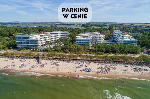 Property building, Nearby landmark, Communal lounge/ TV room, Day, People, Natural landscape, Bird's eye view, View (from property/room), Beach, Evening entertainment, Text overlay, City view, Garden view, Sea view, Swimming pool, group of guests, Parking