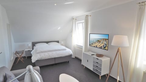 Bed, TV and multimedia, Living room, Seating area, Bedroom