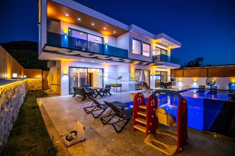 Property building, Patio, Night, Natural landscape, View (from property/room), Balcony/Terrace, Living room, Seating area, Pool view, Swimming pool, sunbed
