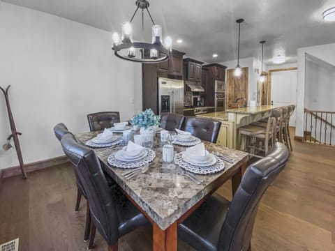 This elegant dining area features a stunning marble-topped table, plush leather chairs, and a modern chandelier. The open layout flows seamlessly into the chef’s kitchen for effortless entertaining.