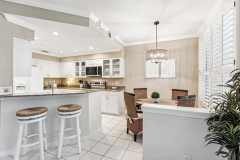 The kitchen has bar stools at the kitchen counter