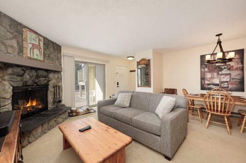 Curl up by your crackling stone fireplace in this cozy living space, where warm flames and comfortable seating create the perfect mountain retreat atmosphere.