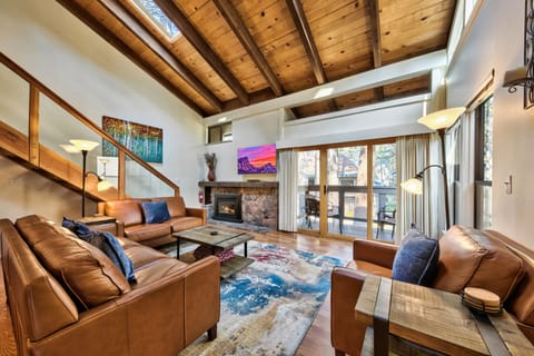Unwind in your spacious living room with soaring wood beams, cozy fireplace, and luxurious leather seating perfect for mountain retreat evenings.