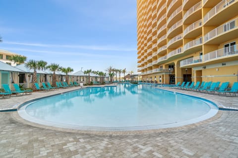 Relax by the large outdoor pool with surrounding lounge chairs at the beachfront property.