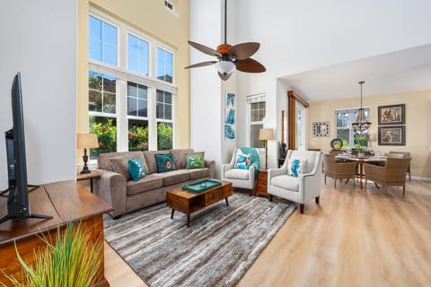 Bright, spacious living room with vaulted ceiling and tall windows