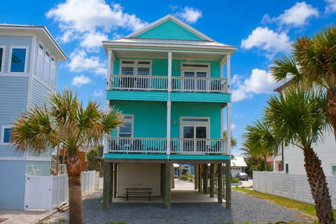 Beachy Bliss: Vibrant exterior with lush palms, perfect for sunny days and ocean views!