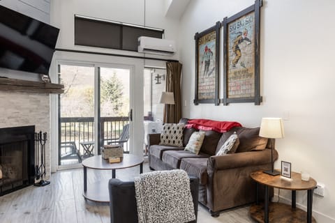 - Cozy living room with fireplace and mountain-inspired décor  
- Sliding glass doors open to a private balcony retreat  
- Relax with smart TV and comfortable sofa after skiing