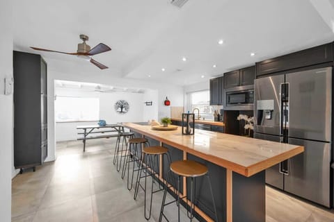 Experience this inviting and fully operational kitchen space. Delight your friends and family with its up to date layout, featuring a spacious two-door fridge, and a beautifully crafted island tabletop.