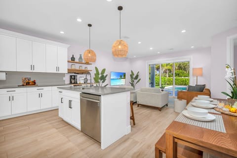 The open plan layout connects the kitchen seamlessly to the dining and living areas, allowing for easy flow and interaction with guests. It's perfect for hosting dinner parties and family gatherings.