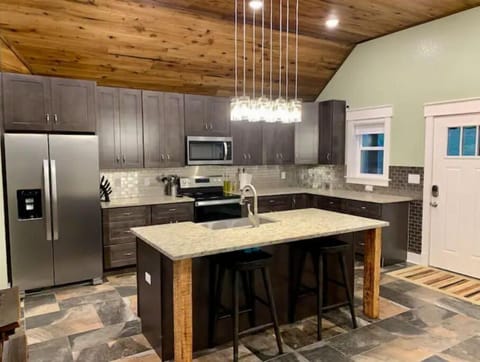Large kitchen island with farm sink and two bar stools.