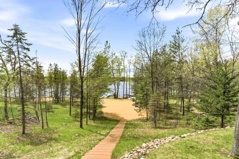 Follow the boardwalk through the trees to a sandy beach and sparkling lake views—your peaceful Up North escape starts here.