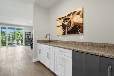 Stylish kitchen featuring a long granite countertop with a sleek sink underneath. The cabinets above the sink provide ample storage, while modern appliances and elegant finishes create a functional and inviting space for cooking and gathering.