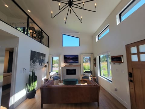 Living room space with tall ceilings, abundant natural light.