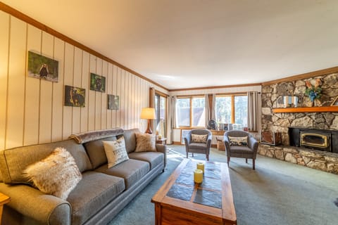 Open living room with bright natural light, wood burning fireplace, and private porch.