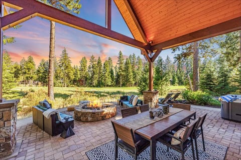 An oasis of relaxation awaits in this high-end mountain home outdoor covered patio that overlooks hole 7 on Rope Rider