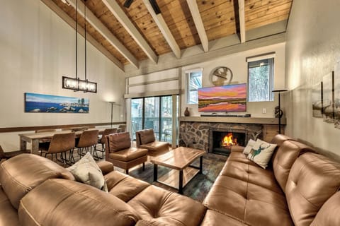 Cozy up by your crackling stone fireplace beneath stunning exposed wood beams. This warm living space invites relaxation with plush leather seating and mountain charm.