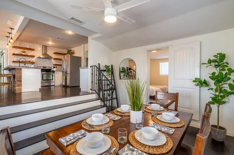 Dining area features a spacious dining table with seating for six, a ceiling fan