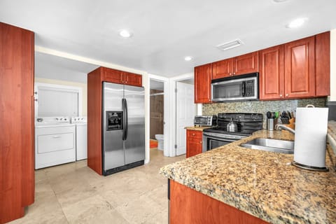 Neat, expansive, and thoughtfully equipped kitchen with ample storage, designed to fulfill your cooking necessities.