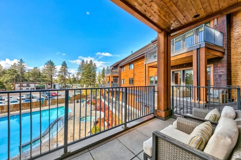 Relax on your private balcony with plush seating overlooking the sparkling pool and mountain pines.