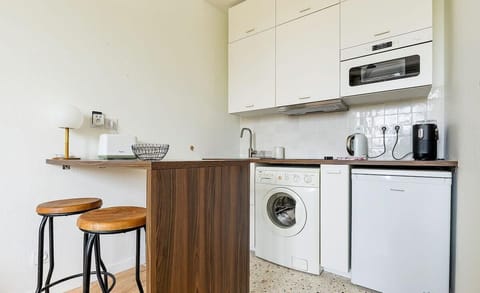 Espace cuisine avec machine à laver, micro-ondes, bouilloire, cafetière et...