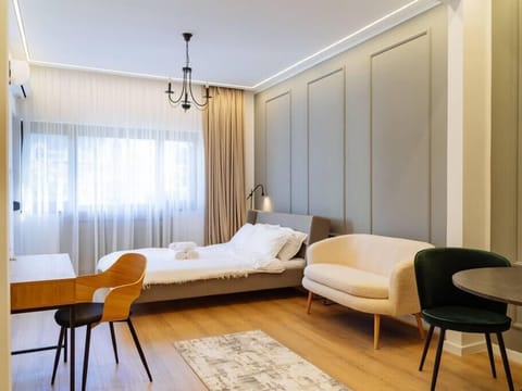 Bedroom/ Living room with a queen sized bed, working desk and dining table for 2, AC, balcony, smart TV and electric exterior blinds 