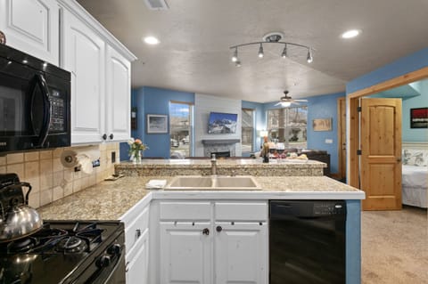 Kitchen looking into living room with ability to watch the evening game