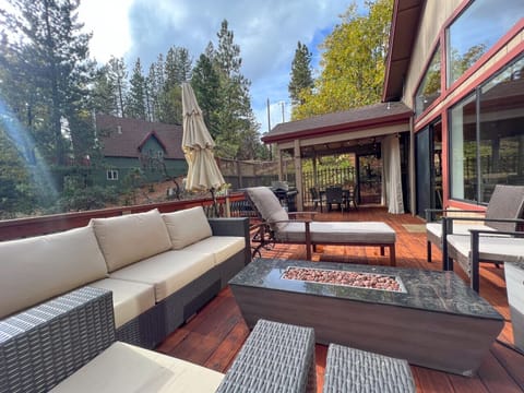 Large main deck with hot tub, fire pit, and dining table. Not to mention beautiful views of the trees!