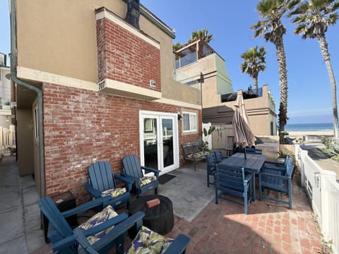 Ocean-view patio with cozy Adirondack seating and outdoor dining