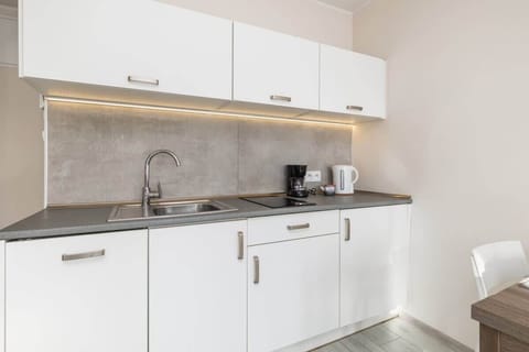 A close-up of the kitchen cabinets, showcasing a coffee maker and neatly arranged items.