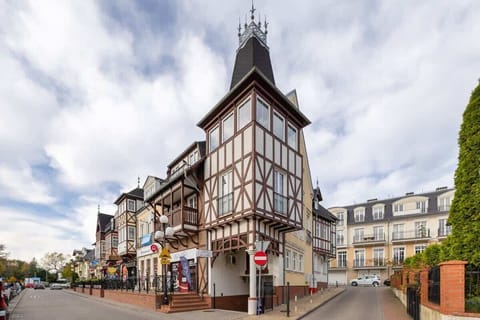 A historic half-timbered building on a European street with classic architecture.