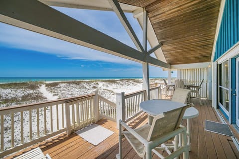 Enjoy a relaxing meal on the spacious deck with beach front views, featuring comfortable seating and a bright atmosphere
