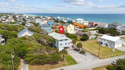 Coastal vacation home nestled among colorful beach houses, just steps from pristine sandy shores and turquoise waters.