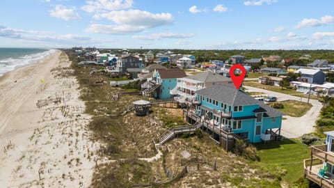 Beachfront vacation rental community with direct beach access and elevated boardwalk paths to sandy shores.